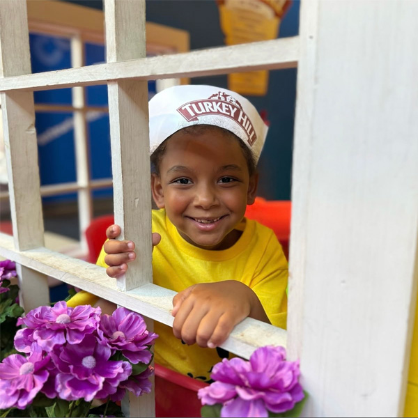 Child smiling through playhouse window